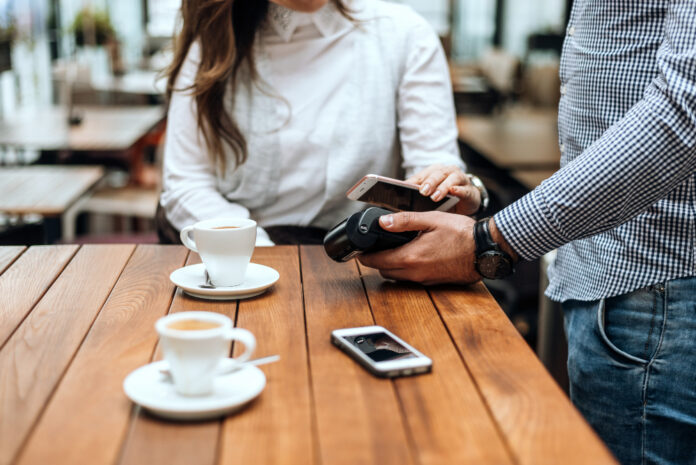 photo-of-woman-using-card-machine-to-pay-using-increased-purchasing-power-Netherlands