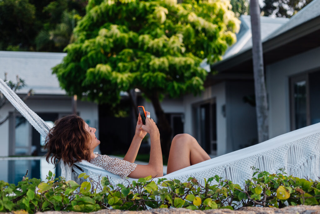 photograph-of-a-woman-scrolling-on-her-phone-whilst-on-vacation